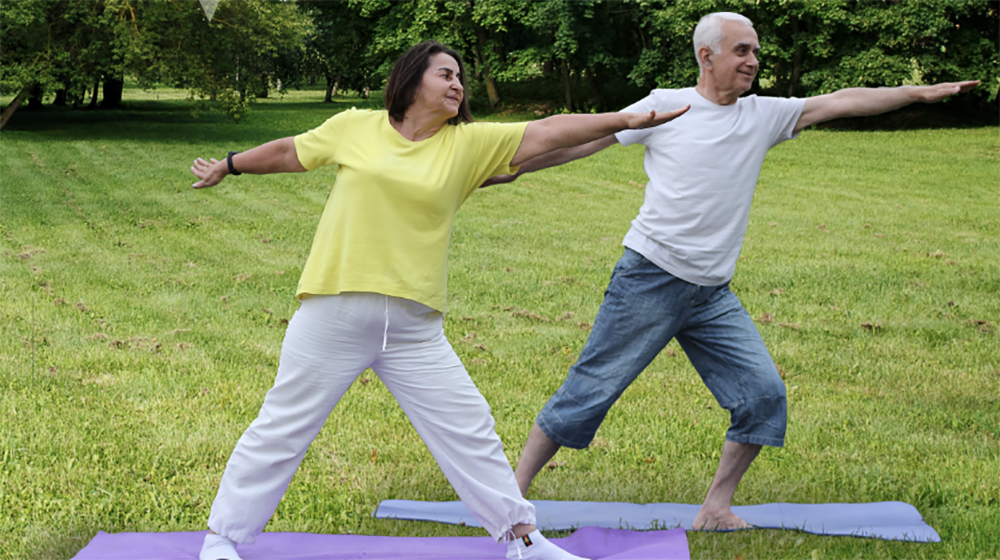 A man and woman stand together in the park doing yoga