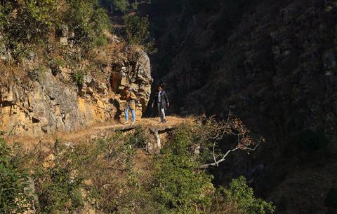 Ms. Bhandari and her colleague Kalawati trek along a steep cliff. They are travelling to rural villages as part of a UNFPA programme supported by the United Kingdom Department for International Development. © UNFPA Nepal