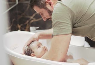 Gabriel Encev bathes his young baby at home in Chisinau, Republic of Moldova.