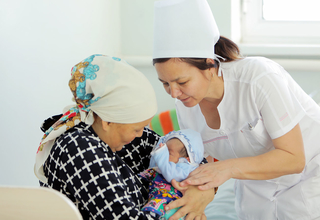 Midwife Venera Jumabayeva assists a new mother