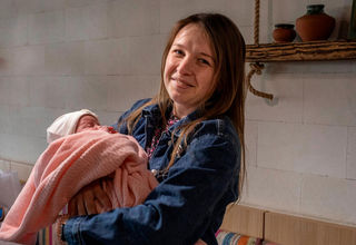 Olga rests with her new daughter after delivering her via caesarean section at the maternity hospital in Balti.
