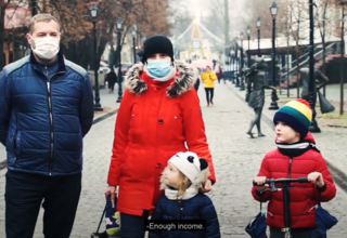 Mom, dad, and two kids being interviewed on a busy street during winter