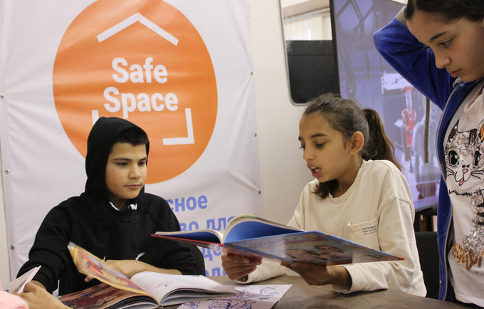 Malina, 12, from Odesa in Ukraine, reads a story to her new friends at a UNFPA-supported youth safe space