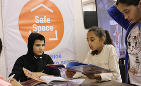Malina, 12, from Odesa in Ukraine, reads a story to her new friends at a UNFPA-supported youth safe space