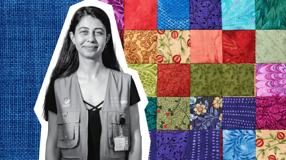 Black and white cutout photo of a young smiling woman in a UNFPA-branded vest. Colorful quilt pattern is placed behind her.