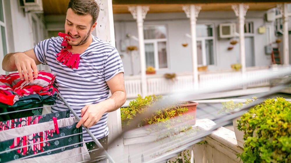 Man standing outside and hanging laundry