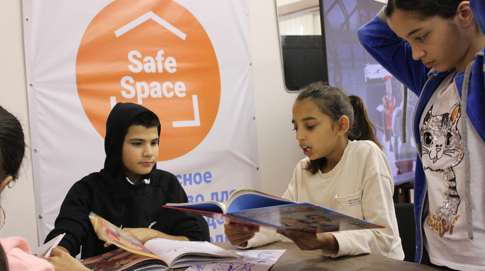 Malina, 12, from Odesa in Ukraine, reads a story to her new friends at a UNFPA-supported youth safe space