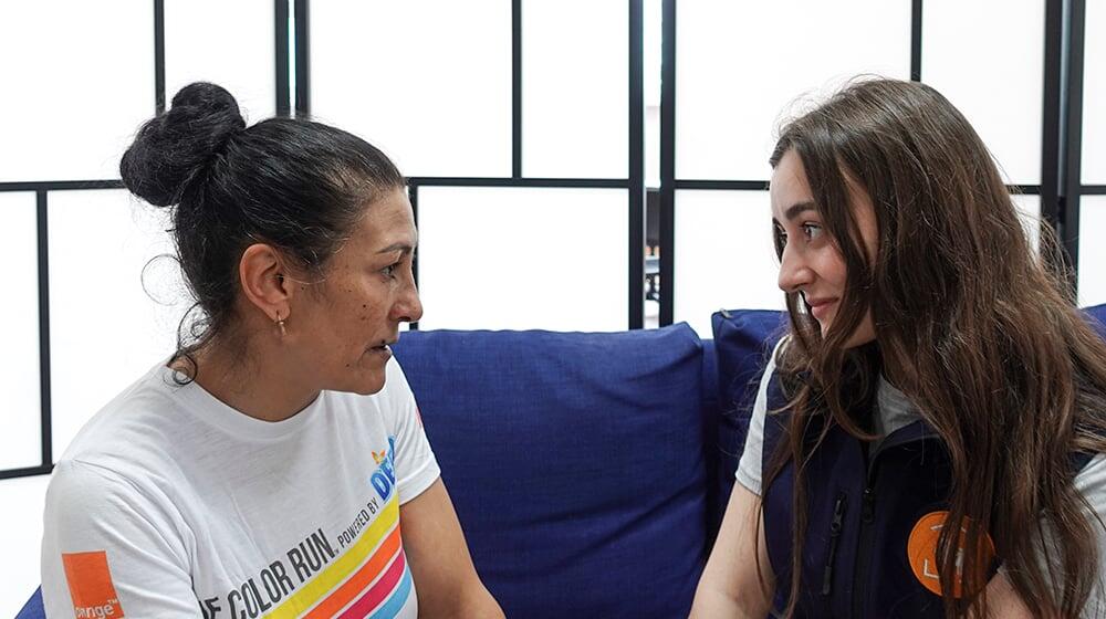 Angela Ciobotaru, a refugee from Ukraine, speaks with a community facilitator at the Women and Girl Safe Space in Bucharest.