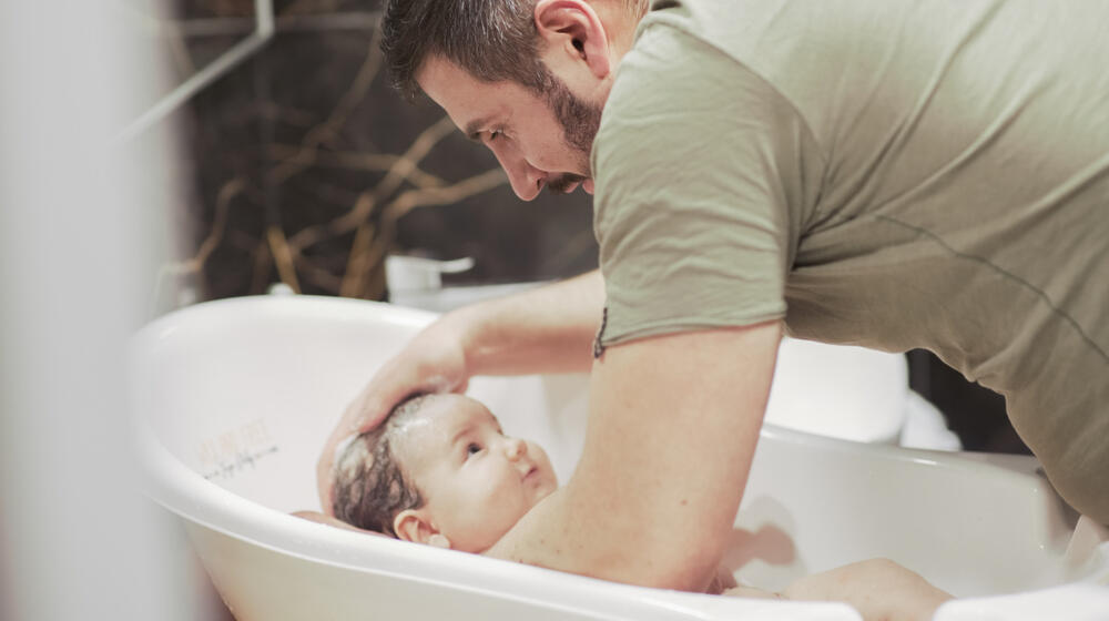 Gabriel Encev bathes his young baby at home in Chisinau, Republic of Moldova.