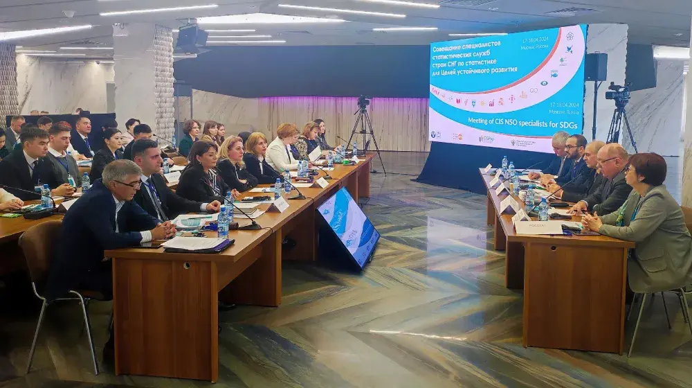 A photo of a meeting room. There is a panel of speakers, and facing them is the audience. 